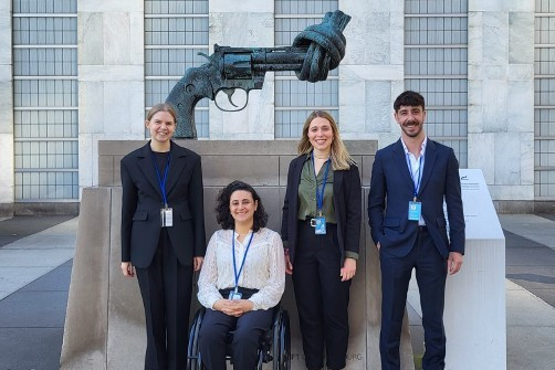 Die Delegation von Handicap International vor der bekannten Skulptur einer riesigen Pistole mit verknotetem Lauf vor dem Headquarter der Vereinten Nationen in New York